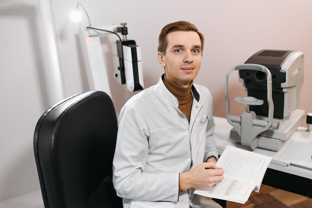 Optometrist at work in clinic with vision test equipment and open book.